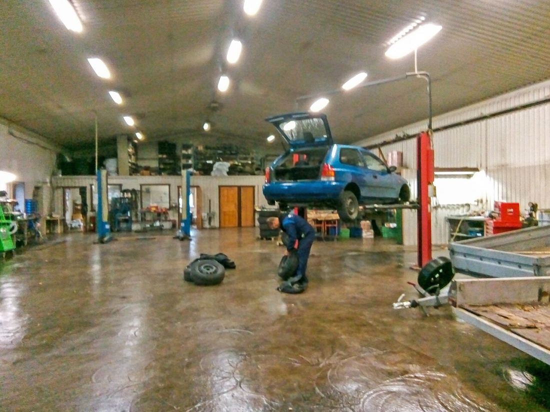 A car on a lift inside a repair garage